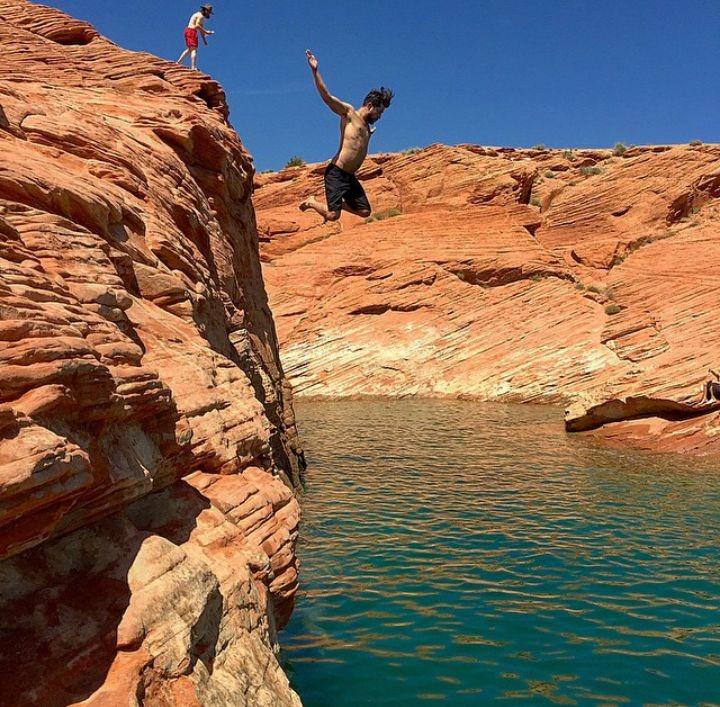 Man cliff jumping into the warm water of Sand Hollow.