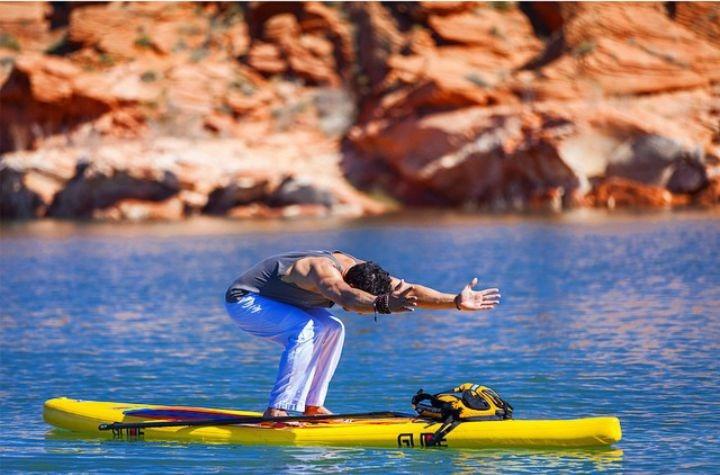 Man doing yoga on paddleboard at Sand Hollow reservoir.